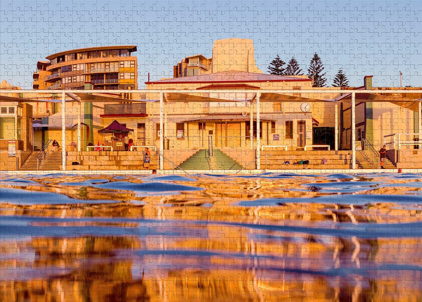 1000-piece Newcastle Ocean Baths jigsaw puzzle featuring the historic Art Deco pavilion reflected in the ocean pool at sunrise