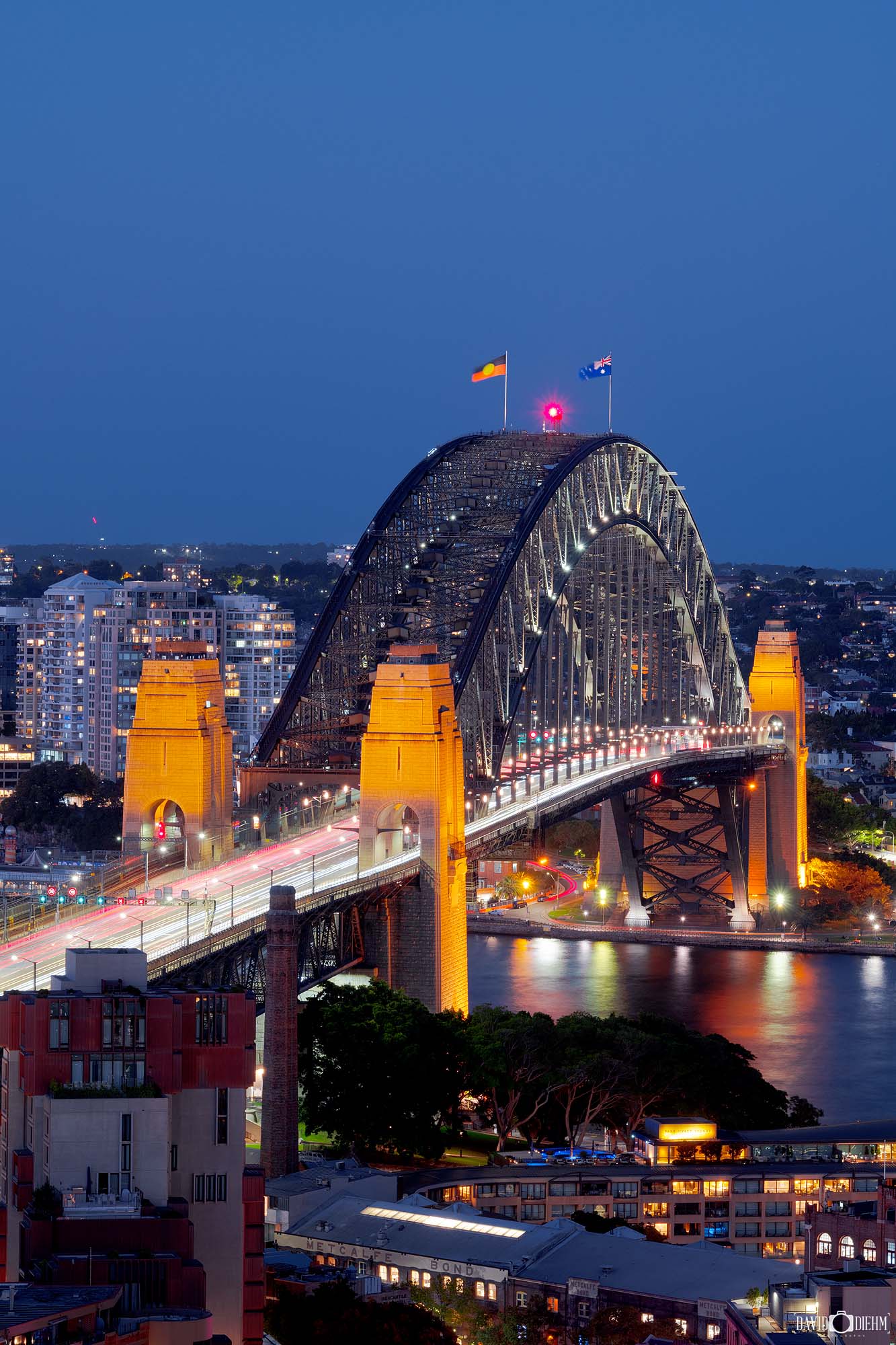 Photograph of the Sydney Harbour Bridge at dusk with deep blue hues and soft twilight tones over Sydney Harbour.