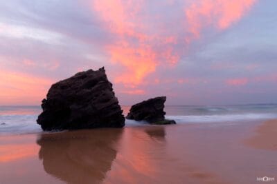 Sunset light illuminating the rocky shoreline at Redhead Beach on the NSW coast.