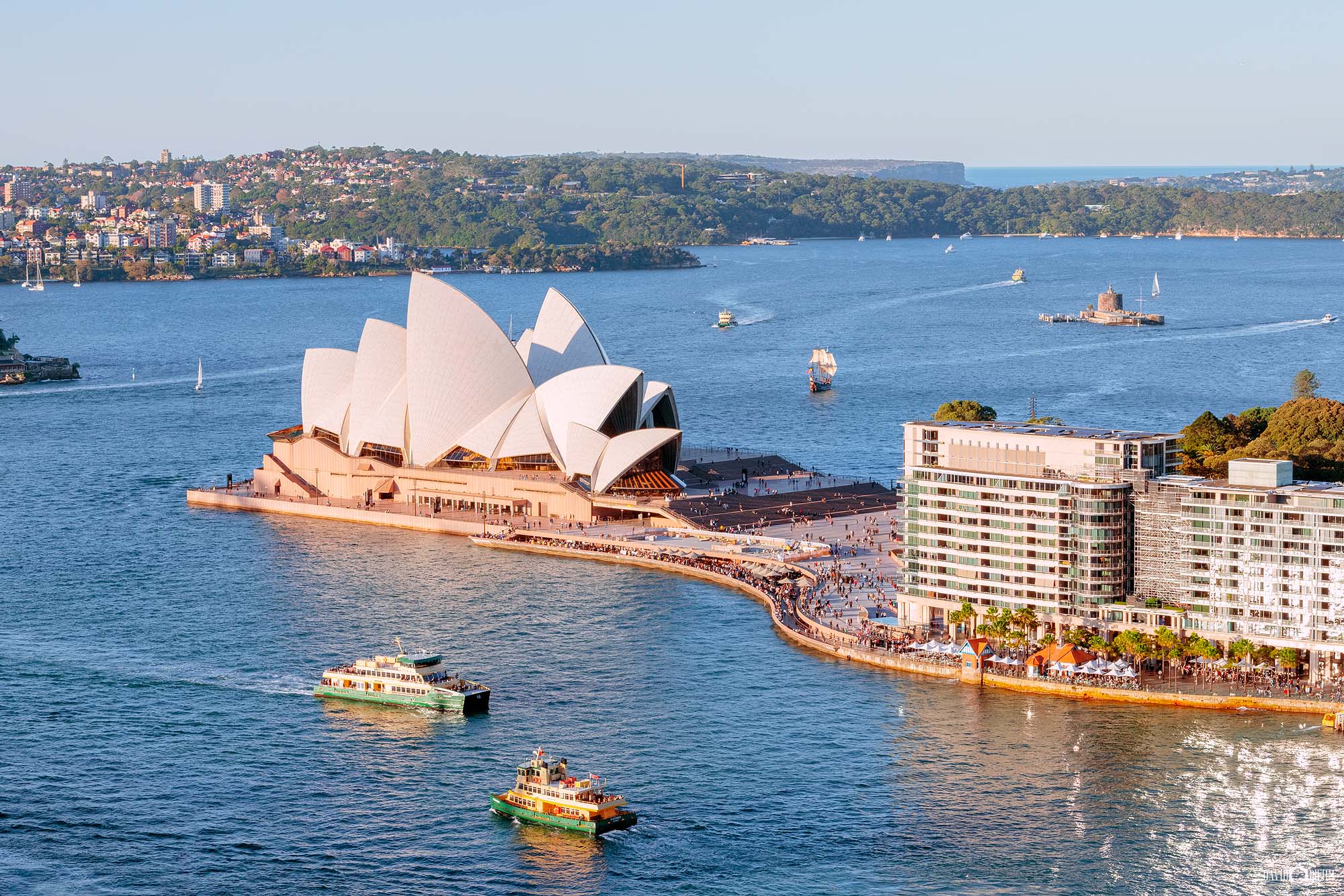 Photograph of the Sydney Opera House in soft afternoon light along Sydney Harbour, highlighting its architectural details and waterfront setting.