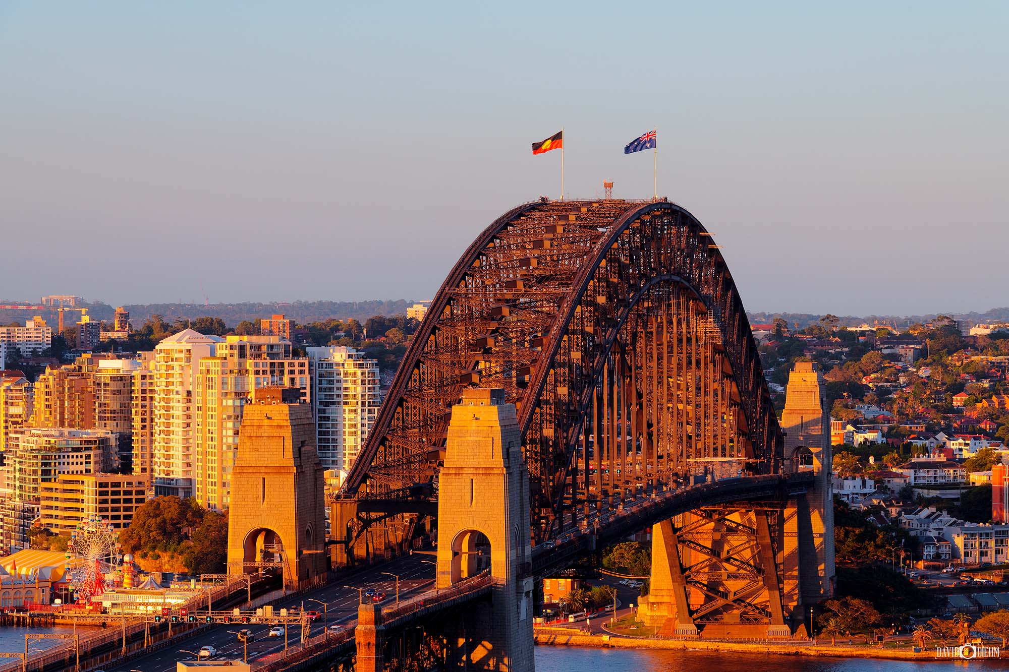 Photograph of the Sydney Harbour Bridge in warm afternoon light with clear skies and harbour views.