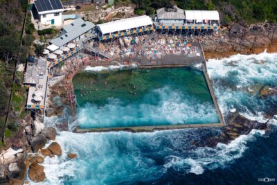 Aerial photograph of Wylie’s Baths in Coogee, Sydney, showing the ocean rock pool, historic timber structures, and coastal cliffs.