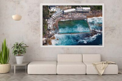 Framed aerial photograph of Wylie’s Baths displayed as modern coastal wall art in an interior setting.