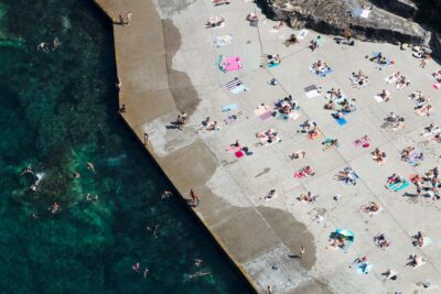 Drone photograph capturing the full sweep of Clovelly Beach, its protected bay, rock edges, and ocean pool along Sydney’s eastern coastline.