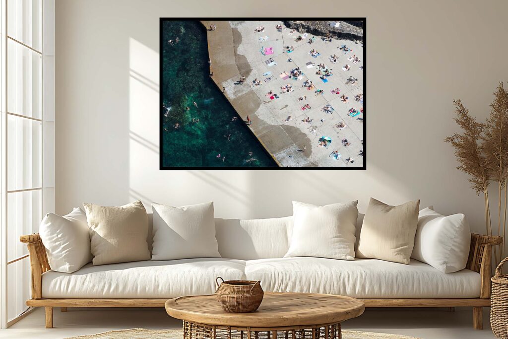 Framed aerial print of Clovelly Beach styled as contemporary coastal artwork in a modern interior setting.