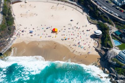 Aerial photograph of Tamarama Beach in Sydney, Australia, showing the small bay, turquoise water, and surrounding cliffs.