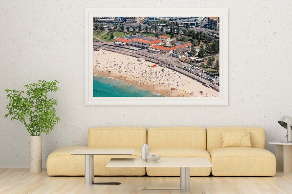 Framed aerial photograph of Bondi Pavilion displayed as modern coastal wall art in a contemporary interior.