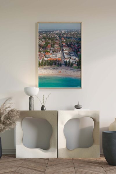 Framed aerial photograph of Coogee Beach displayed as modern coastal wall art in an interior space.