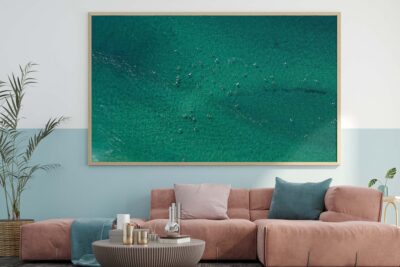 Aerial photograph of surfers riding waves in the ocean at Bondi Beach in Sydney, capturing the surf action and coastline from above.