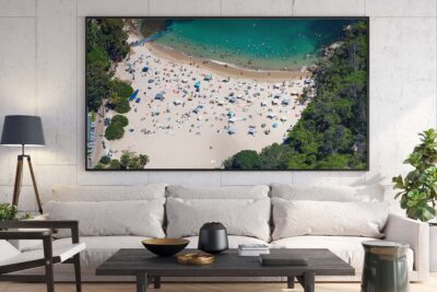 Framed aerial photograph of Shelly Beach in Manly displayed as modern coastal wall art in an interior space.