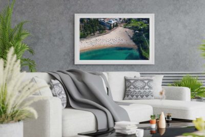 Framed aerial photograph of Coogee Beach displayed as modern coastal wall art in an interior setting.