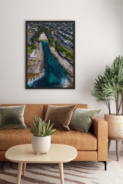 Framed aerial photograph of Clovelly Beach displayed as modern coastal wall art in a contemporary interior.