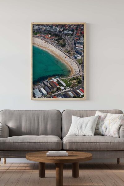 Framed aerial photograph of Bondi Beach displayed as modern coastal wall art in a contemporary interior.