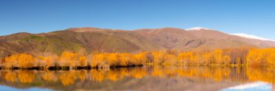 Calm lake reflections in New Zealand with mountains mirrored in still water