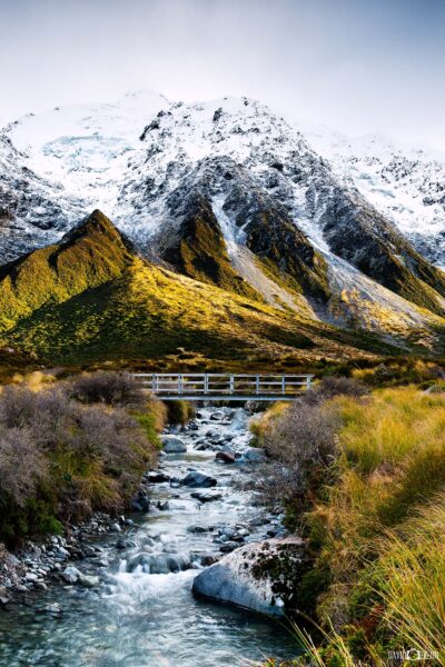 Sunrise over snow covered mountains at Aoraki / Mount Cook National Park with Hooker Valley stream in the foreground