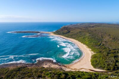 Aerial view of Moonee Beach in Lake Macquarie on a perfect summer morning with soft sunlight and clear coastal water
