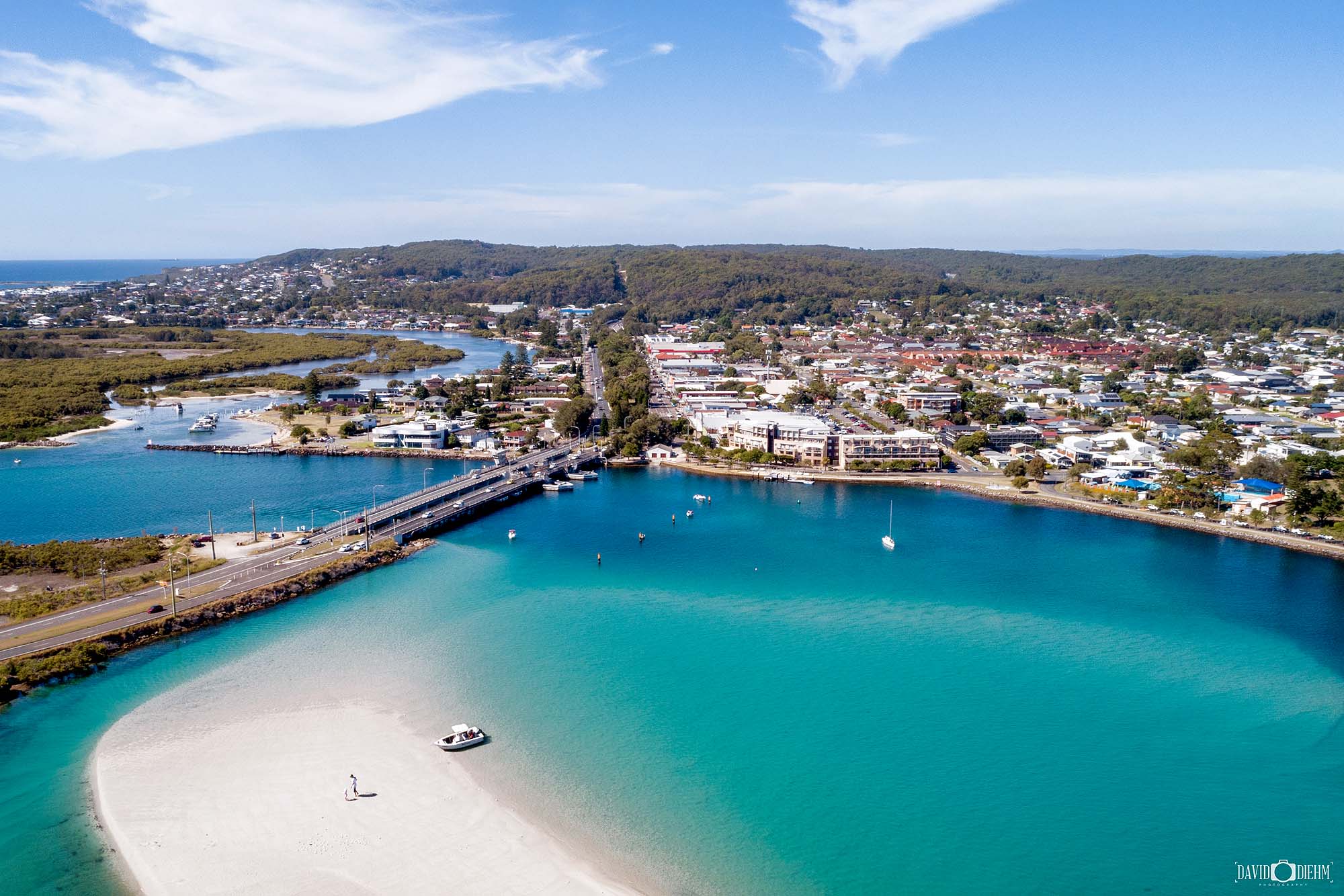 Aerial view of Swansea Bridge in Lake Macquarie at low tide with visible sandbar and exposed channel flats