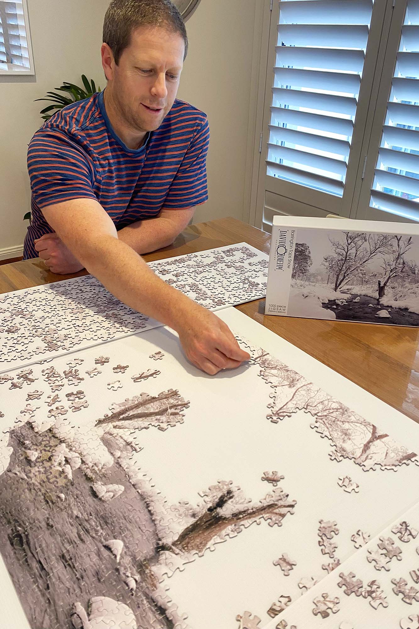 Hands assembling a Newcastle and Lake Macquarie jigsaw puzzle