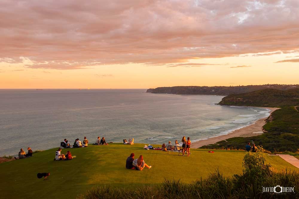 Visitors enjoying sunset views from Hickson Street Lookout overlooking Glenrock State Conservation Area and Burwood Beach