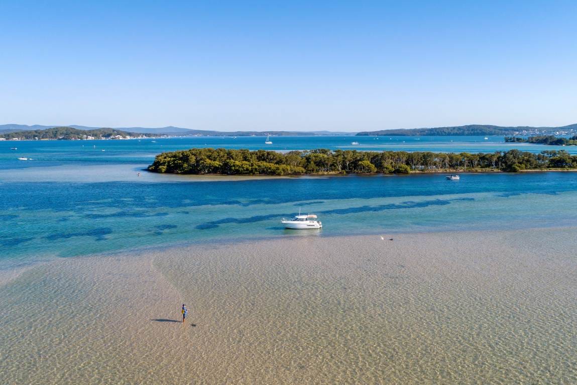 Boat anchored beside Elizabeth Island in the clear shallow waters of Lake Macquarie NSW