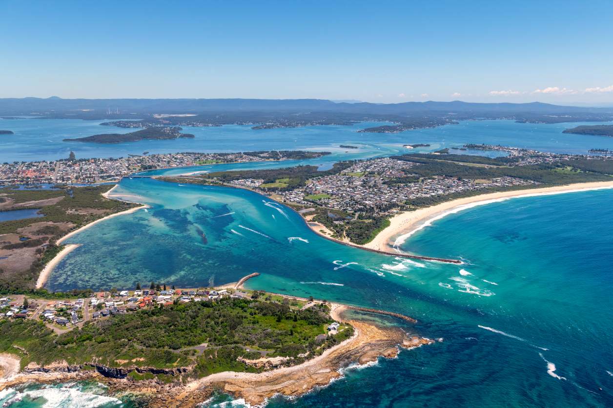Aerial view of Lake Macquarie showcasing crystal-clear turquoise water, sandy islands and Australia's largest coastal saltwater lake