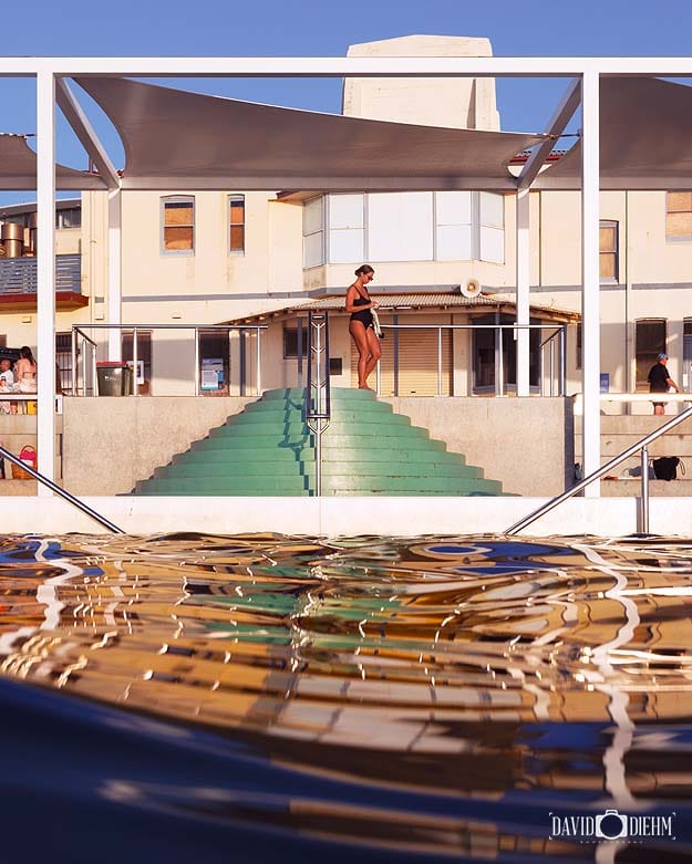 Morning reflections and swimmers at Newcastle Ocean Baths in Newcastle NSW