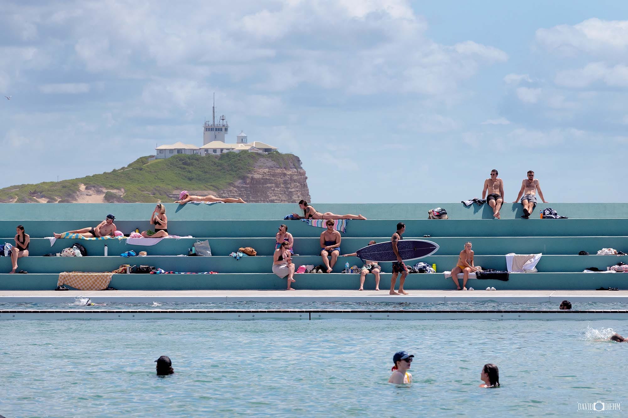 Visitors swimming and relaxing at Newcastle Ocean Baths beside Newcastle Beach in NSW Australia