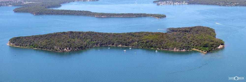 Aerial view of Pulbah Island in Lake Macquarie NSW showing the island's dense bushland surrounded by expansive blue waterways.