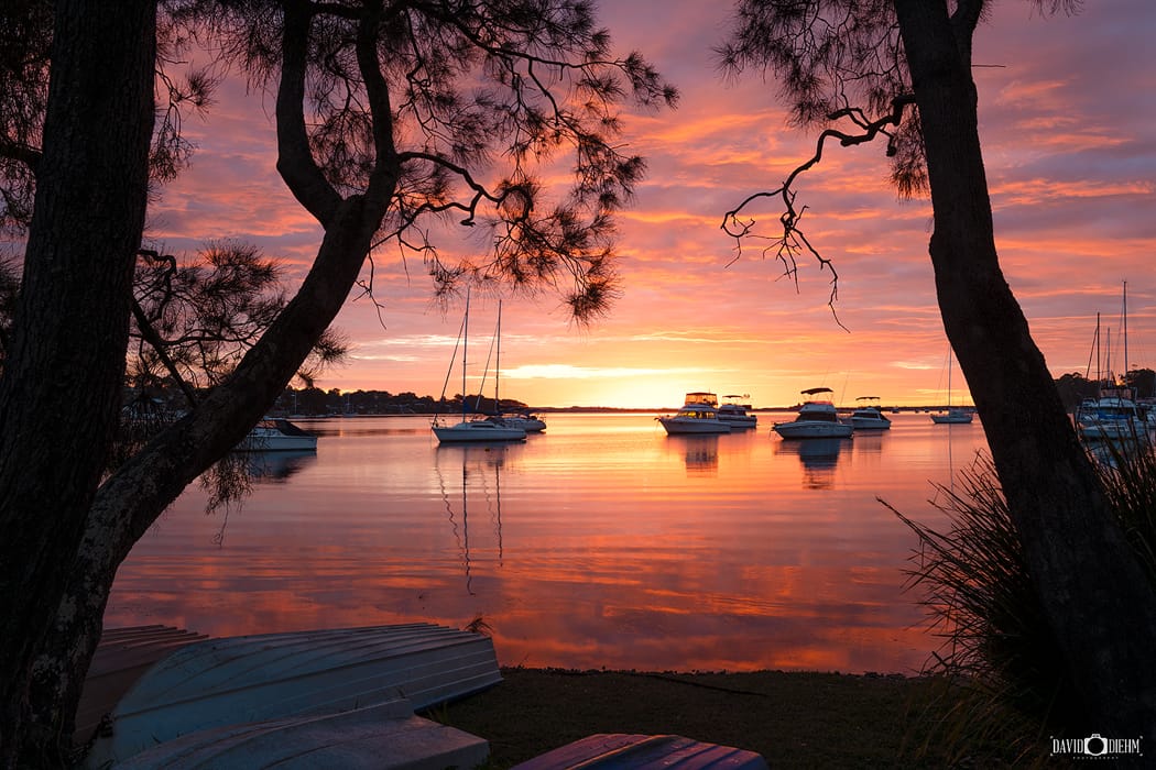 Colourful sunset over moored boats on the Wangi Wangi waterfront in Lake Macquarie NSW