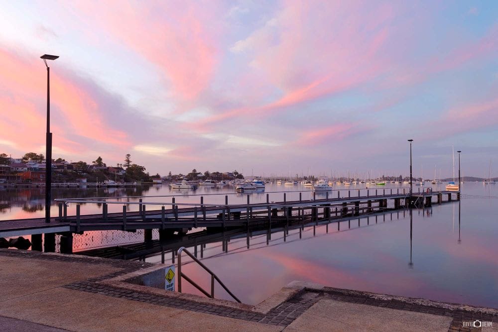 Sunrise over Belmont Baths jetty and moored boats on Lake Macquarie NSW