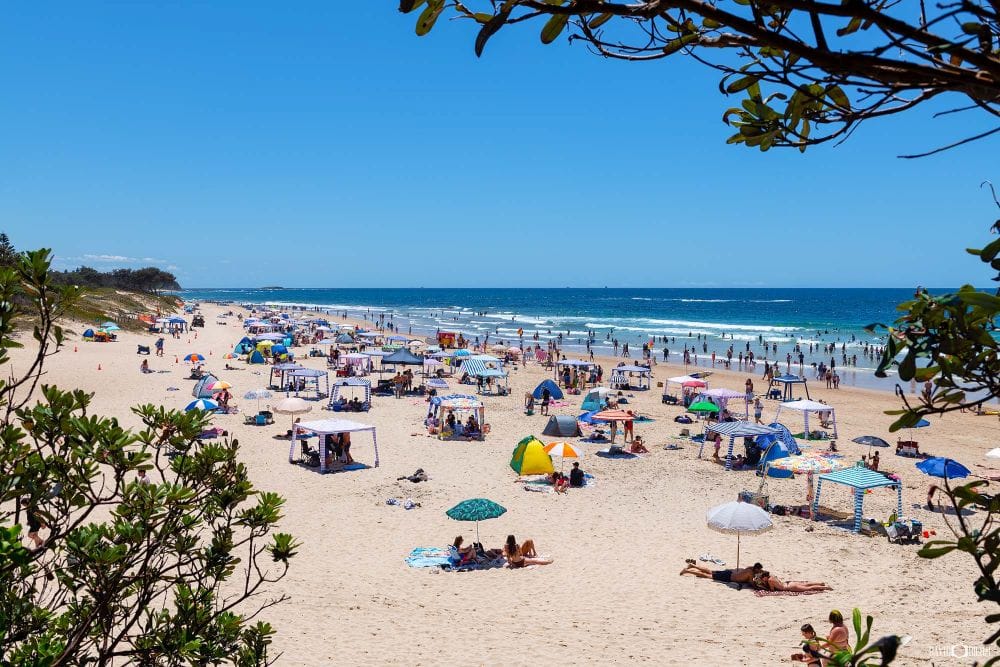 Visitors enjoying Caves Beach on a summer day with golden sand and rolling surf in Lake Macquarie NSW