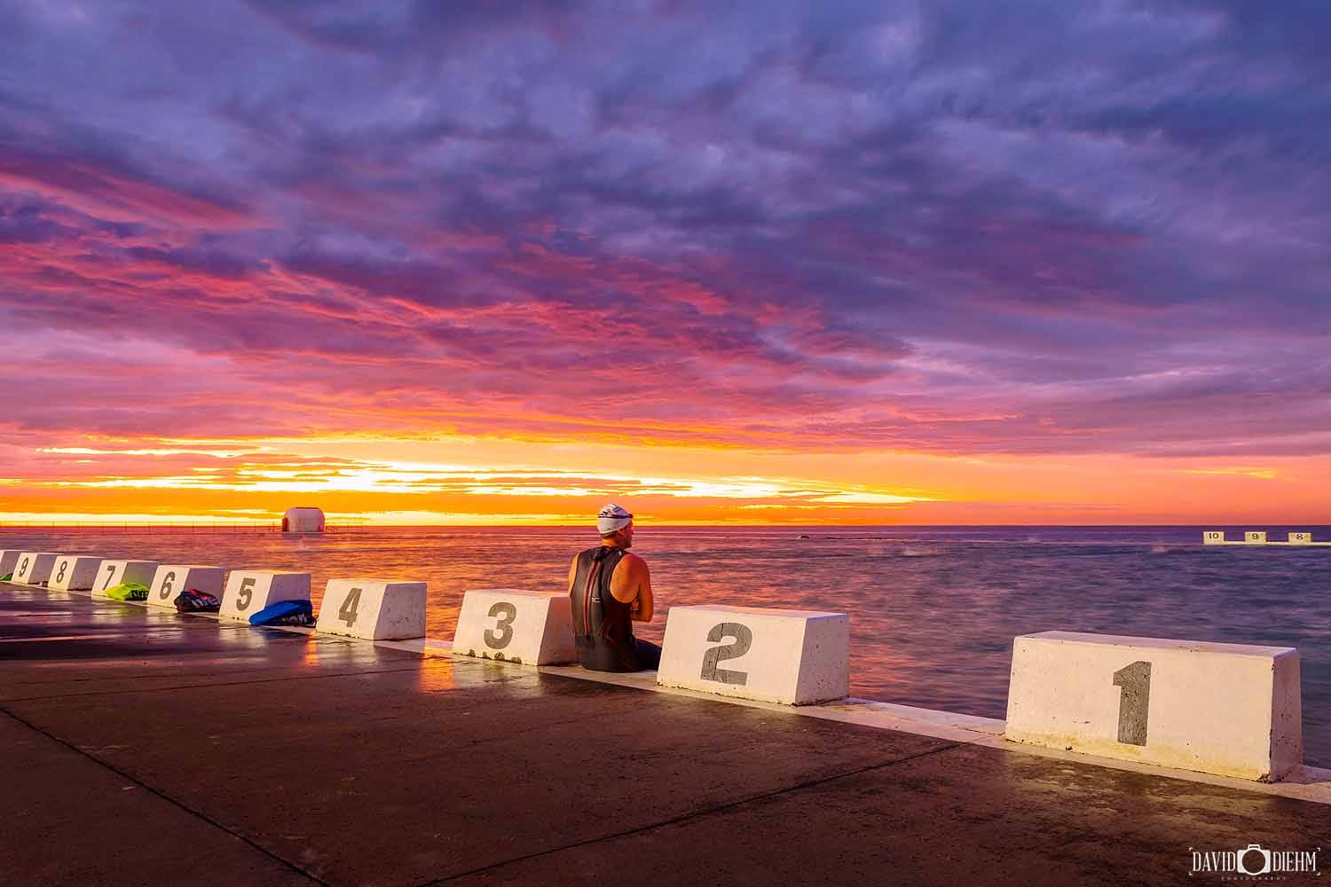 merewether-ocean-baths-sunrise-swimmer.jpg A swimmer watching sunrise from Merewether Ocean Baths in Newcastle, NSW.