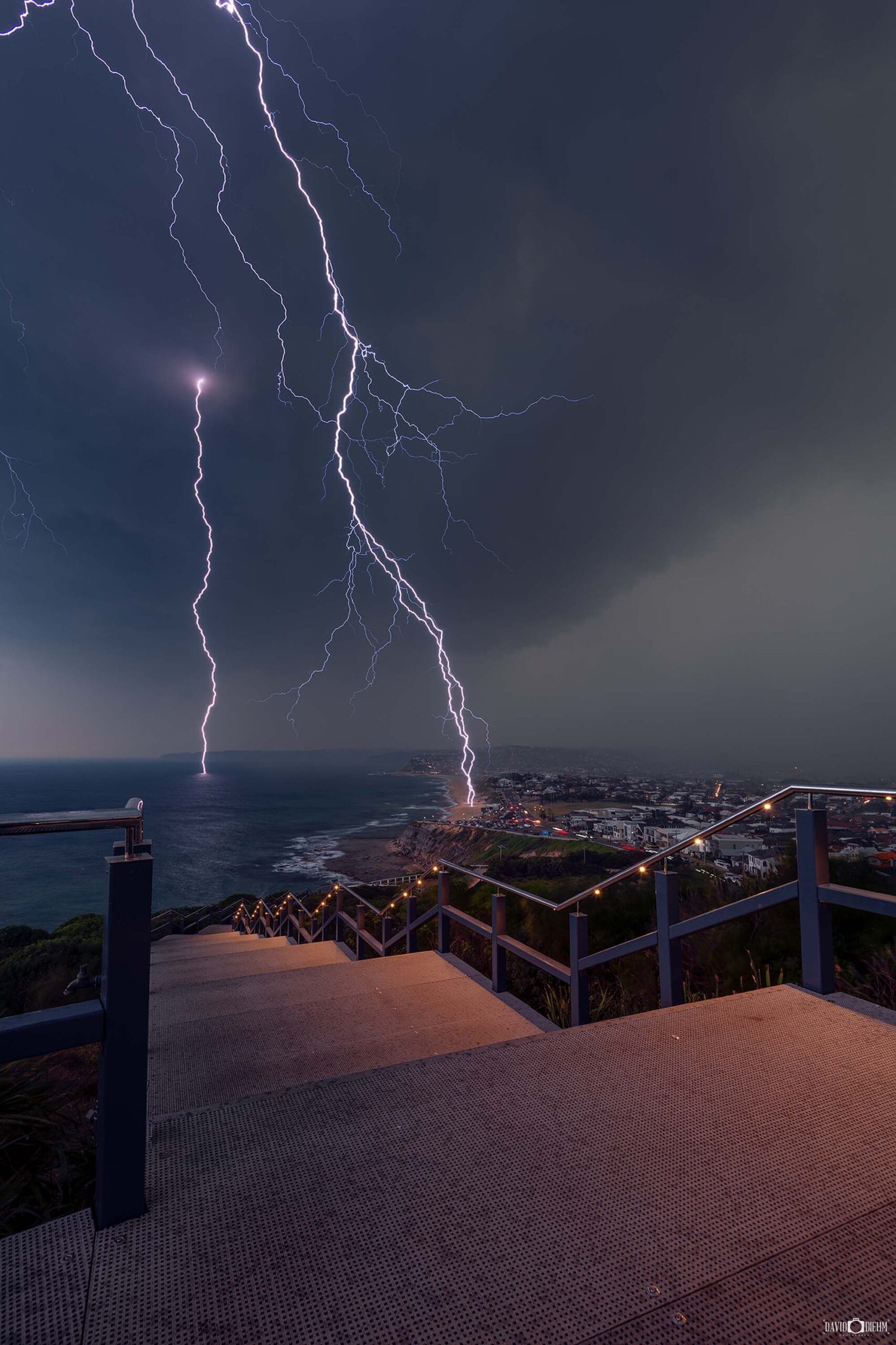 Twin lightning bolts striking Bar Beach viewed from ANZAC Memorial Walk in Newcastle NSW
