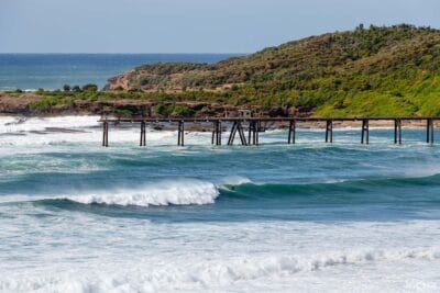 Surfer paddling through large ocean swell off Catherine Hill Bay on the NSW coast