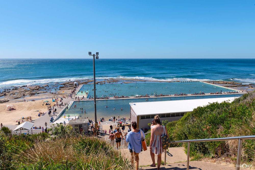 Visitors walking down from the Merewether Ocean Baths Lookout overlooking the ocean baths in Newcastle NSW.