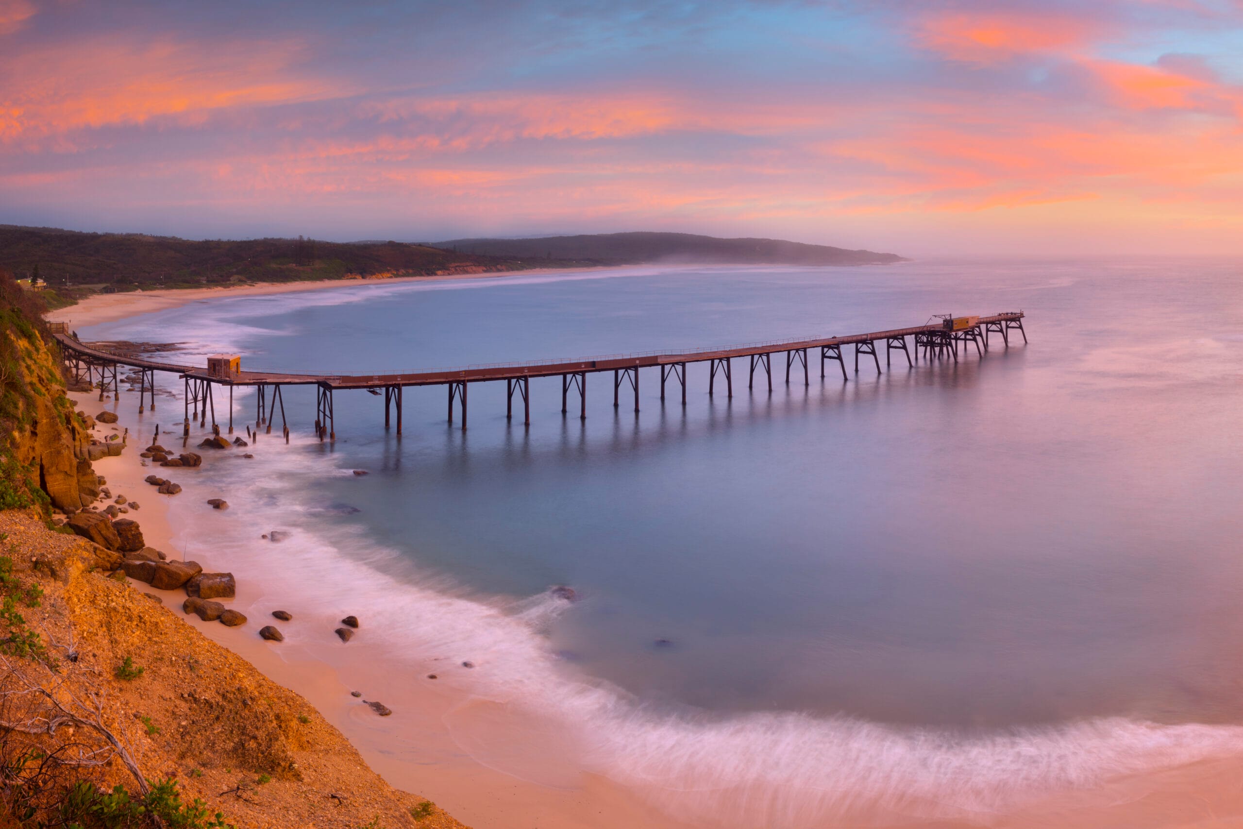 Historic coal-loading jetty at Catherine Hill Bay during sunrise in Lake Macquarie NSW.