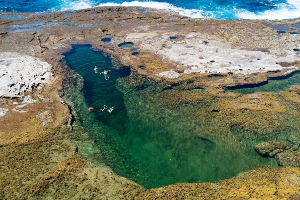 Natural ocean pool and snorkelling hole at Catherine Hill Bay with crystal-clear water.