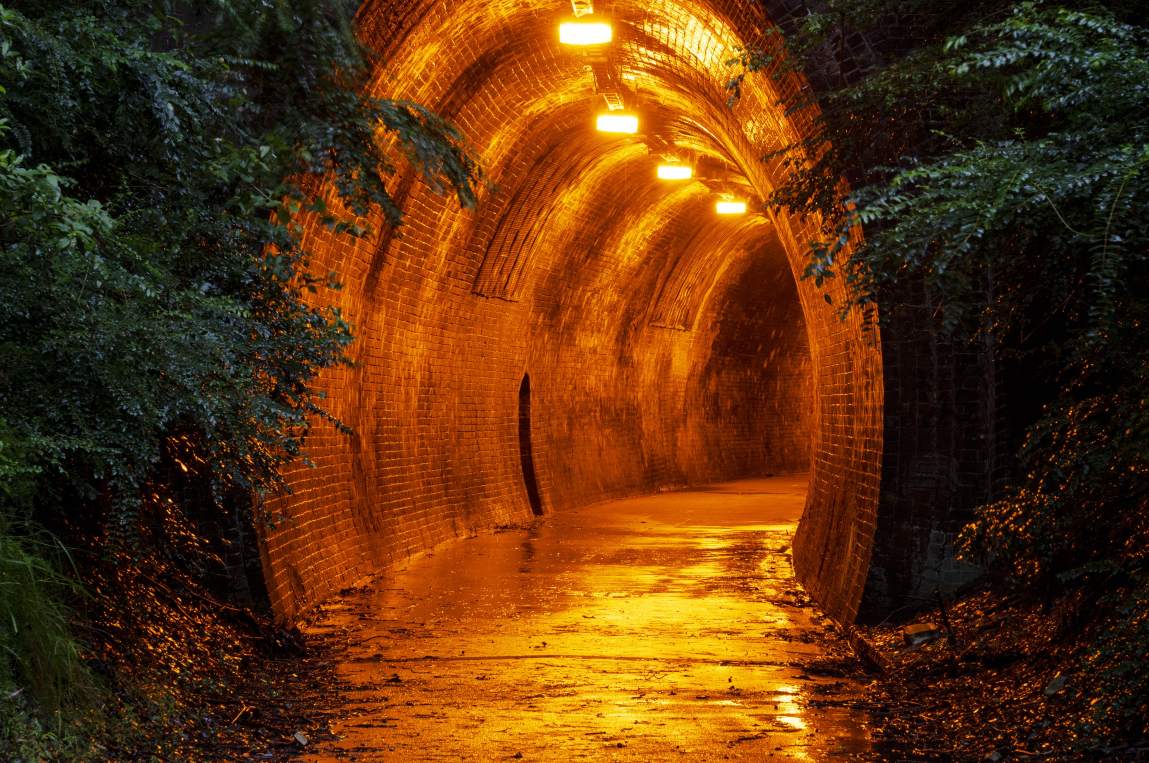 The historic Fernleigh Track Tunnel illuminated at dusk along the popular Fernleigh Track cycling and walking trail in Newcastle.