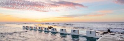 Sunrise illuminating the iconic concrete blocks at Merewether Ocean Baths in Newcastle NSW