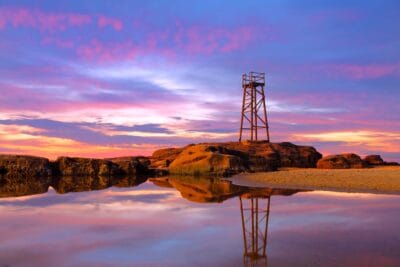 Glowing sunrise reflections surrounding the iconic Redhead Shark Tower at Redhead Beach NSW