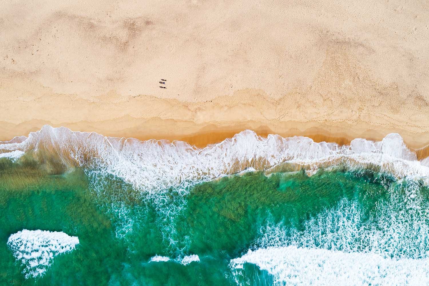 Aerial view of Glenrock Lagoon Beach near Newcastle, showing turquoise ocean water, golden sand and the coastline reached via the Yuelarbah Walking Track.