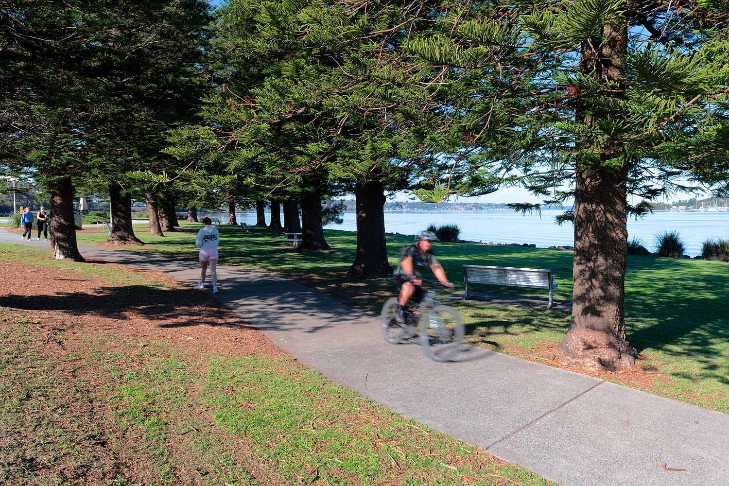 Cyclists and walkers enjoying the Warners Bay Foreshore shared pathway beside Lake Macquarie.
