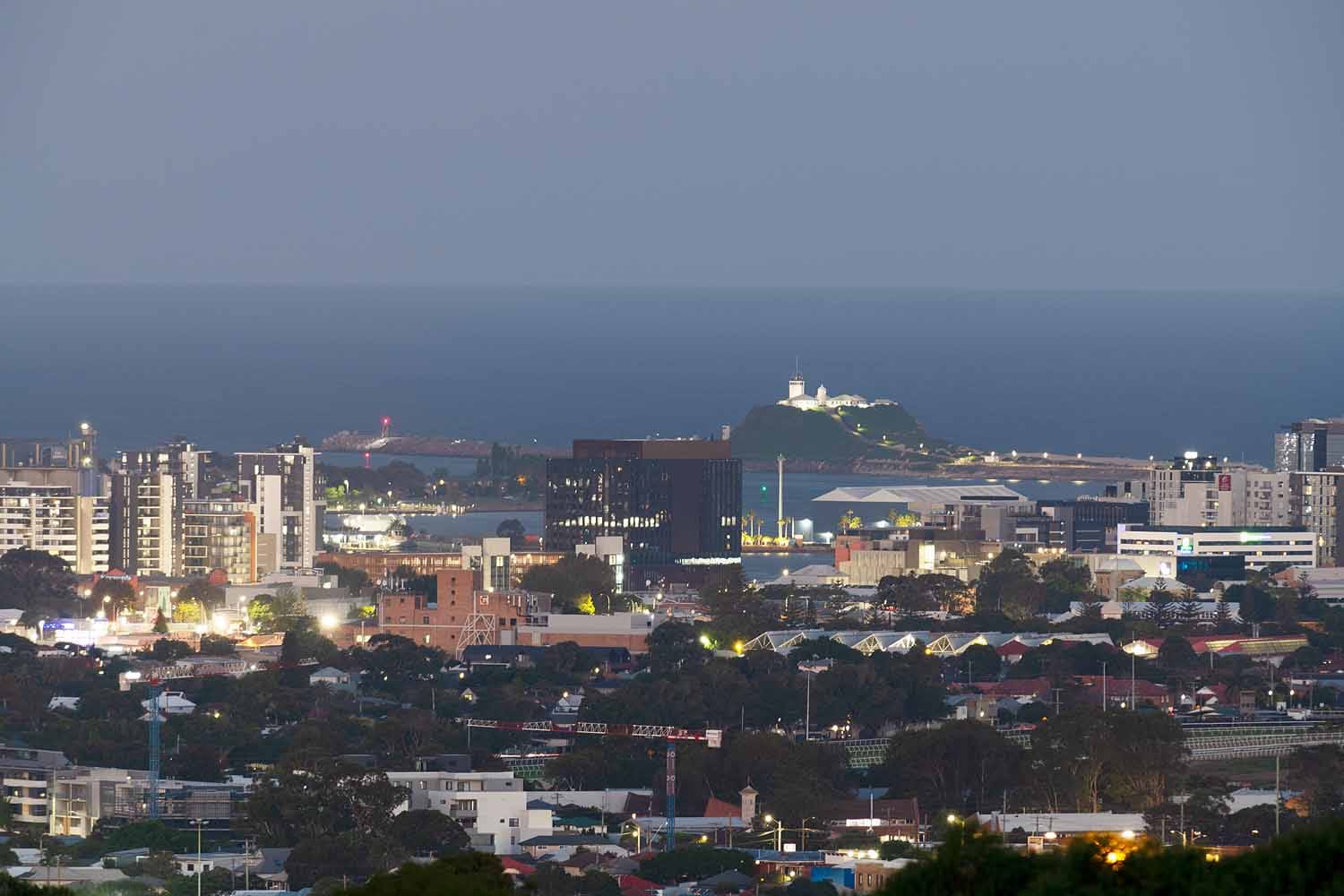 Evening view from New Lambton Heights Lookout overlooking Newcastle CBD, Newcastle Harbour and Nobbys Lighthouse.