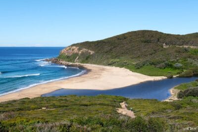 Trail runners crossing the bridge over Glenrock Lagoon in Glenrock State Conservation Area, Newcastle NSW.