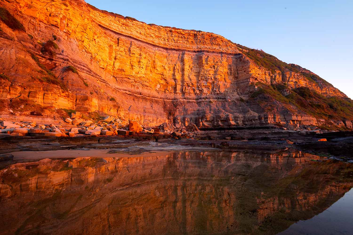 Ancient sedimentary rock layers exposed in the coastal cliffs near Susan Gilmore Beach on the Newcastle GeoTrail.