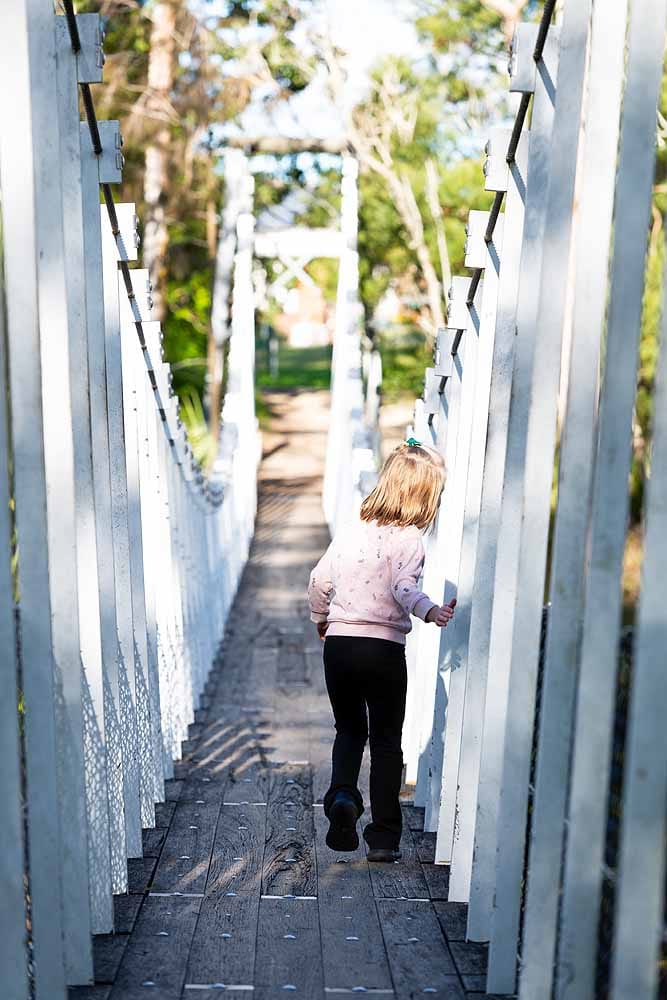 Child walking across the historic Cooranbong Swing Bridge above Dora Creek in Lake Macquarie.