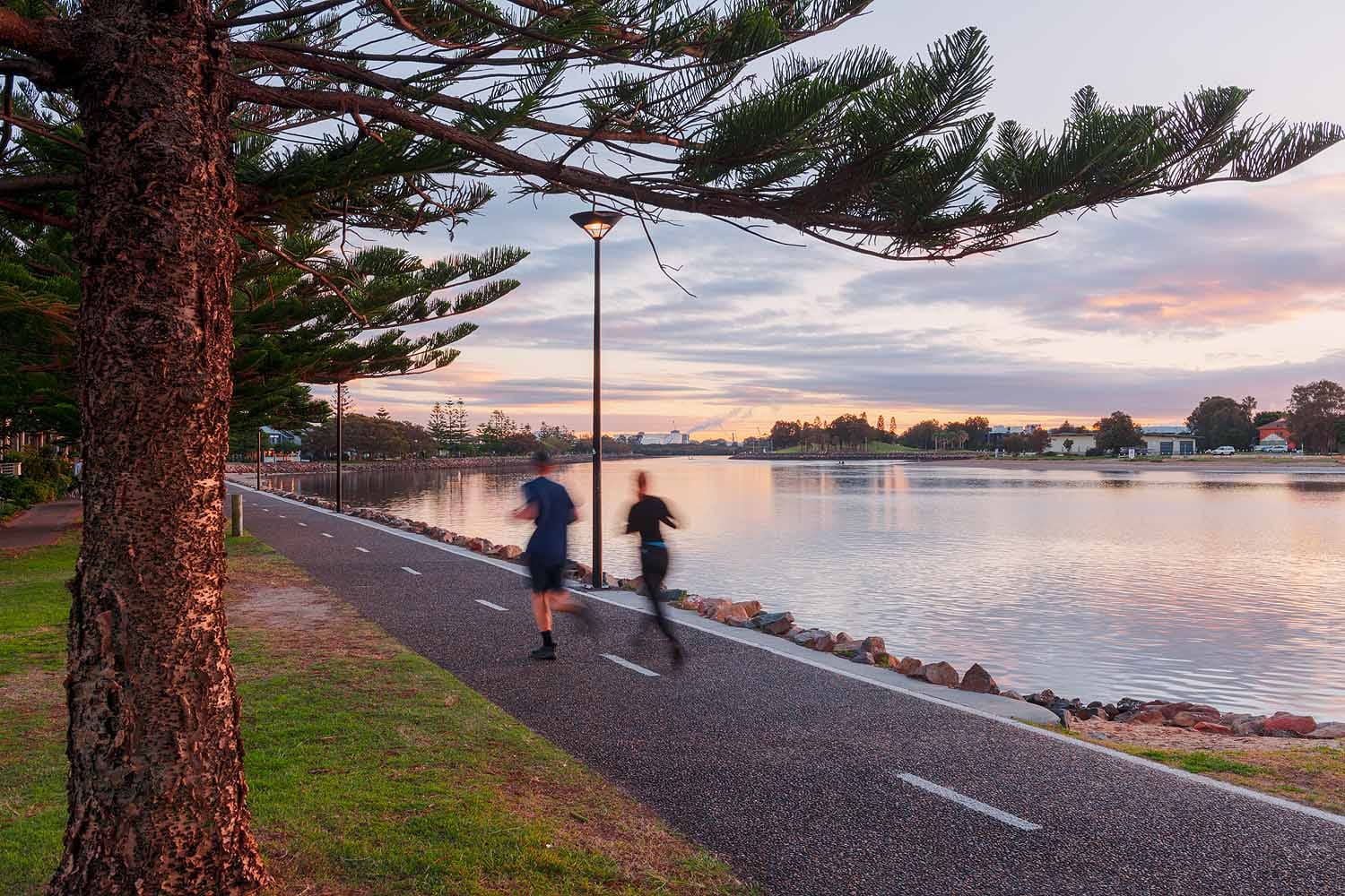 Joggers using the Throsby Creek shared pathway beside the waterfront in Newcastle.