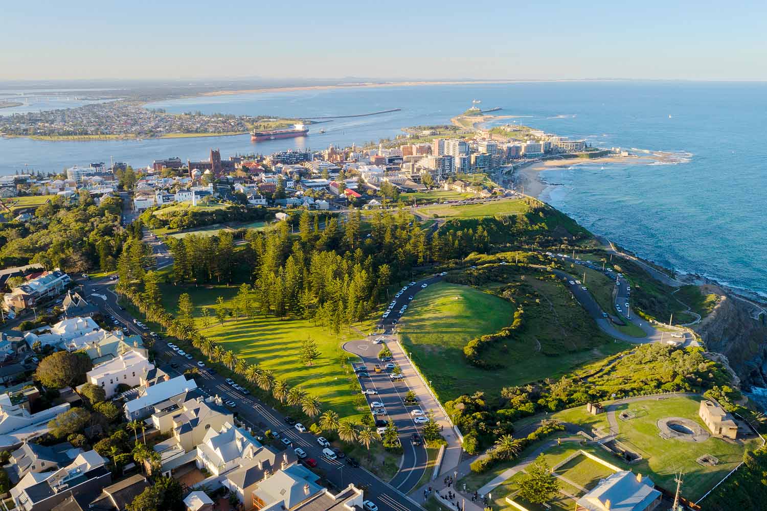 Aerial view of King Edward Park overlooking Newcastle Harbour, the city skyline and Pacific Ocean in Newcastle NSW.