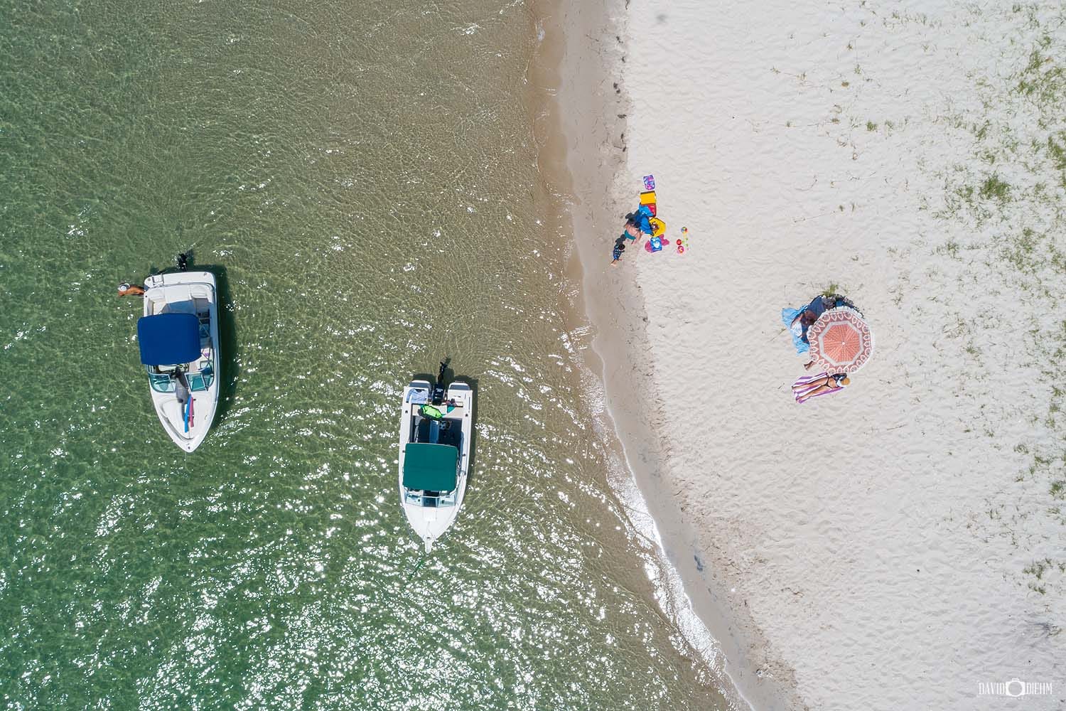 Boats anchored beside the white sandy shoreline of Naru Beach in Lake Macquarie