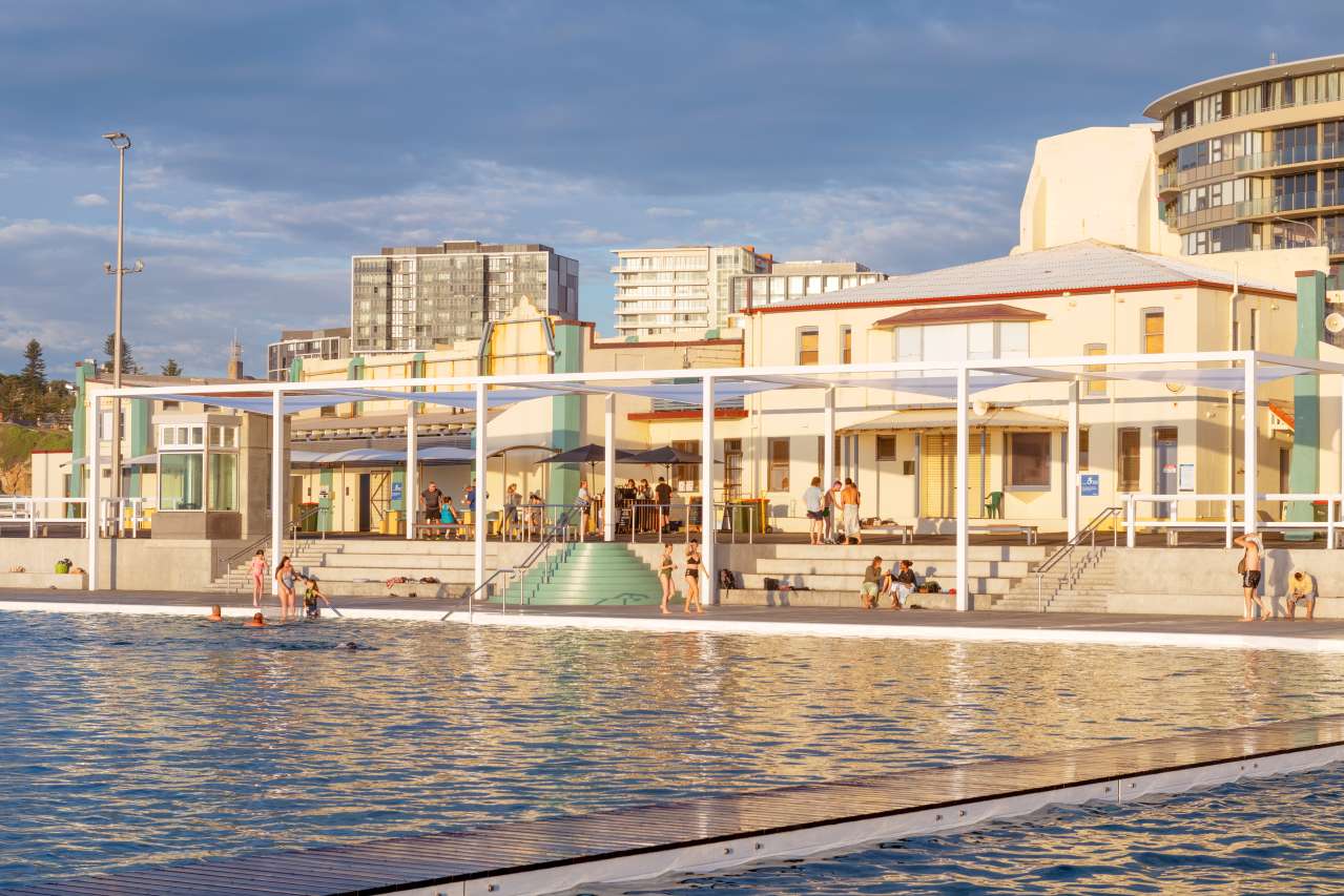 newcastle-ocean-baths-art-deco-pavilion.jpg Historic Art Deco pavilion at Newcastle Ocean Baths with swimmers and Newcastle city buildings behind.